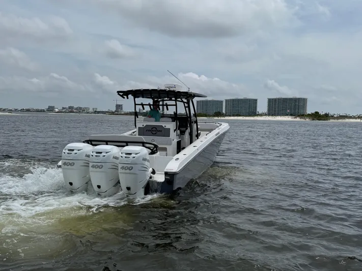  Yacht Photos Pics 2022 Fountain 38TE boat with triple engines cruising on water near cityscape.