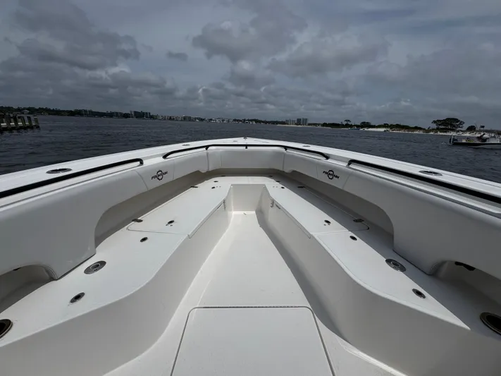  Yacht Photos Pics 2022 Fountain 38TE boat interior with spacious seating, on a cloudy day by the water.