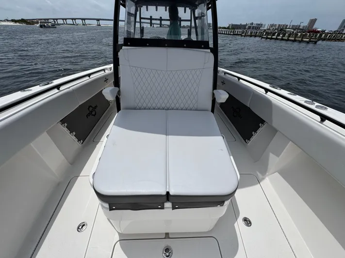  Yacht Photos Pics 2022 Fountain 38TE boat with white seating, docked near a bridge and waterfront.