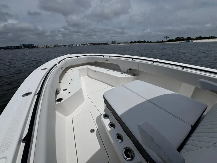  Yacht Photos Pics 2022 Fountain 38TE boat with spacious seating, cruising on a calm waterway under cloudy skies.