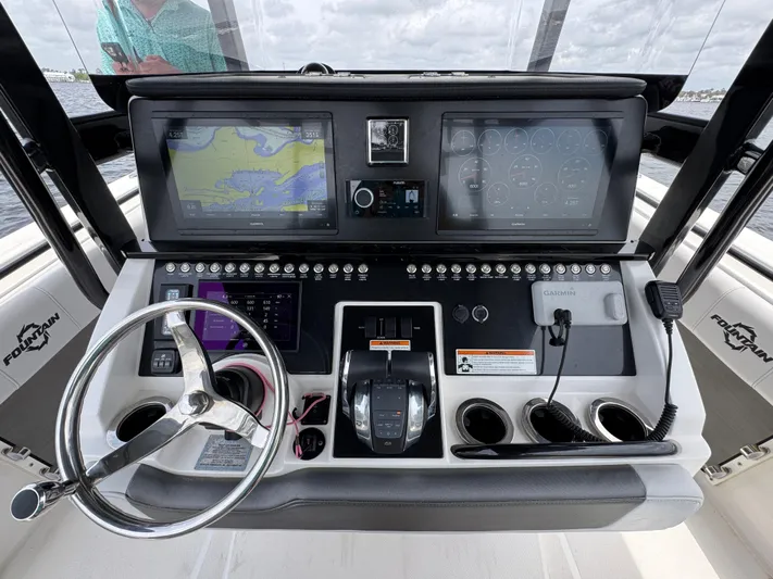  Yacht Photos Pics Control panel of a 2022 Fountain 38TE boat with navigation screens and steering wheel.