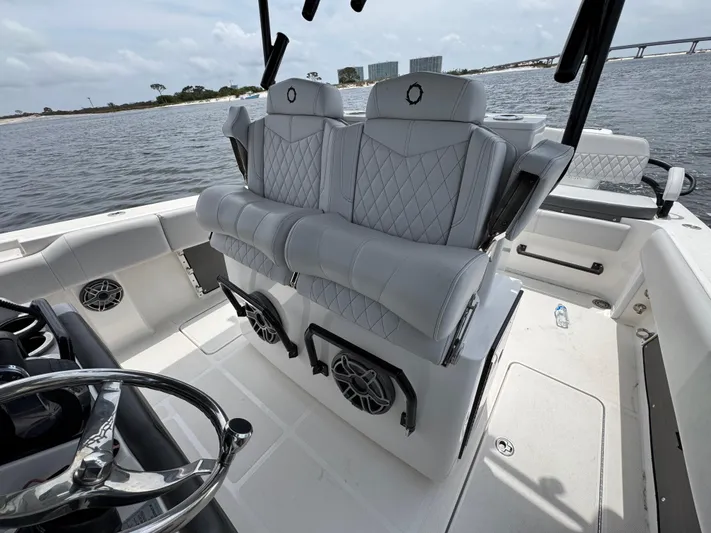  Yacht Photos Pics 2022 Fountain 38TE boat interior with luxury seating and steering wheel, on calm water.
