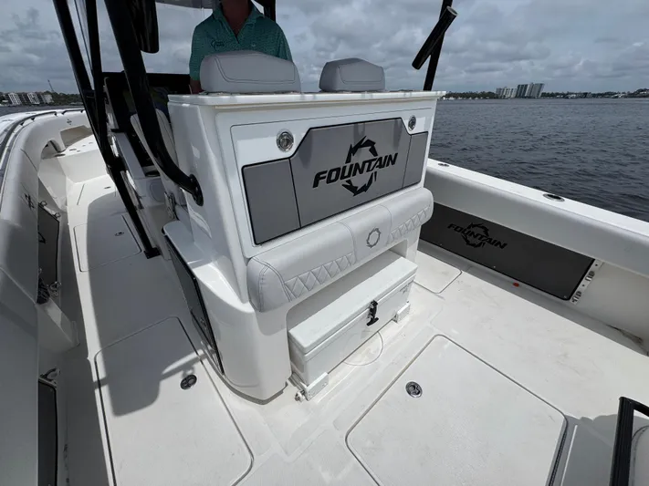  Yacht Photos Pics 2022 Fountain 38TE boat interior with seating and storage, on a calm water backdrop.