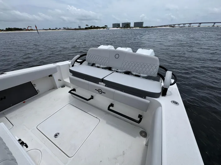  Yacht Photos Pics 2022 Fountain 38TE boat interior with seating, on calm water near a bridge.