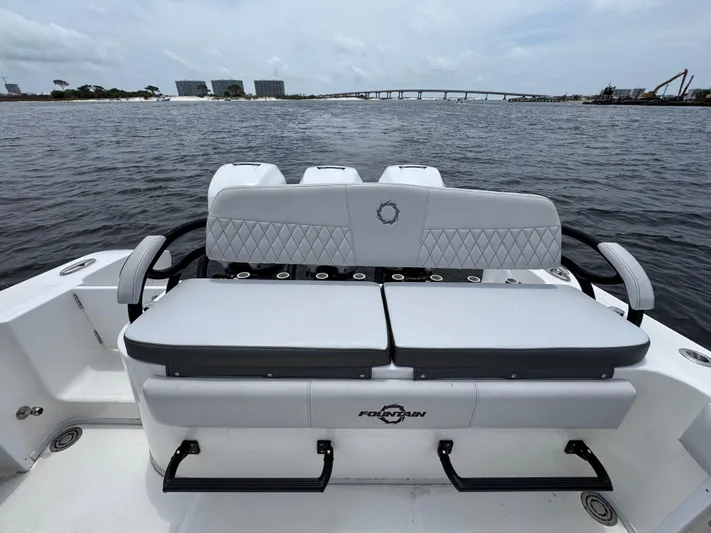  Yacht Photos Pics 2022 Fountain 38TE boat with cushioned seating, overlooking a scenic waterfront view.