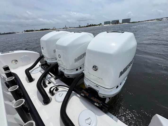  Yacht Photos Pics Triple Mercury outboard engines on a 2022 Fountain 38TE boat, docked on a calm waterway.