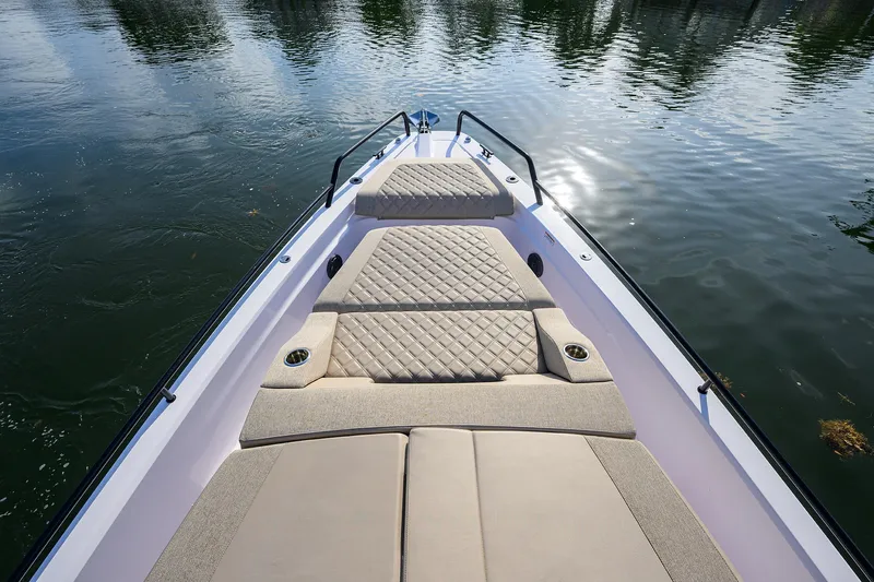  Yacht Photos Pics 2024 Axopar XC Cross Cabin Brabus boat with cushioned deck on calm water.