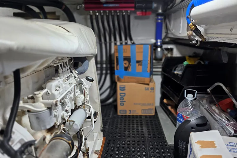 Aspen Afloat Yacht Photos Pics Engine room of a 1974 Chris-Craft Roamer with visible machinery and storage items.