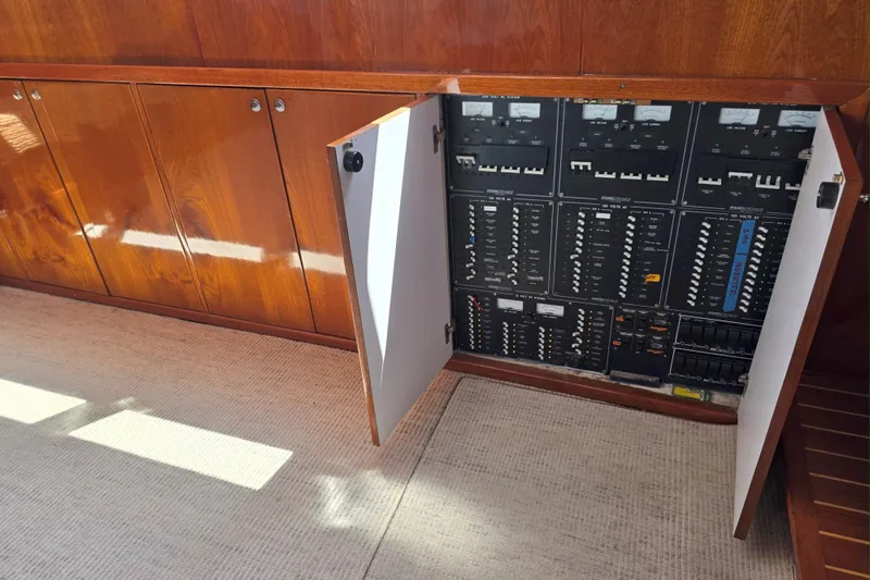 Aspen Afloat Yacht Photos Pics 1974 Chris-Craft Roamer electrical panel with open cabinet, showcasing control switches and circuits.