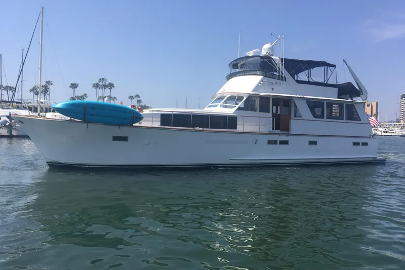 Aspen Afloat Yacht Photos Pics 1974 Chris-Craft Roamer yacht docked in marina, featuring a sleek design and blue kayak.