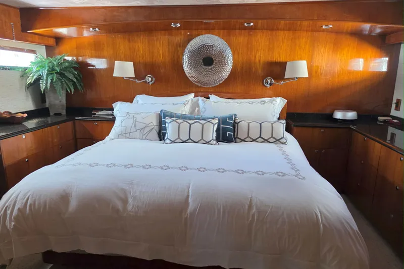 Aspen Afloat Yacht Photos Pics Luxurious bedroom interior of a 1974 Chris-Craft Roamer yacht with elegant wood paneling.