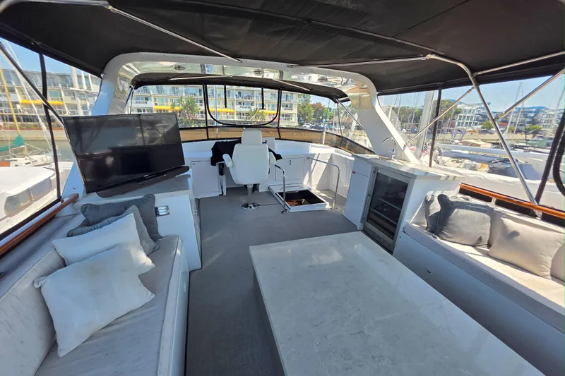 Aspen Afloat Yacht Photos Pics Luxurious 1974 Chris-Craft Roamer yacht interior with seating, TV, and marina view.