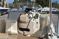2016 Quicksilver Activ 605 Open boat interior with steering wheel and seating.