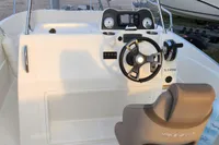 2016 Quicksilver Activ 605 Open boat dashboard with steering wheel and controls.