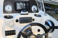 Control panel of 2016 Quicksilver Activ 605 Open boat with steering wheel and gauges.
