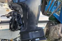 Outboard motor on a 2016 Quicksilver Activ 605 Open boat, parked on gravel.