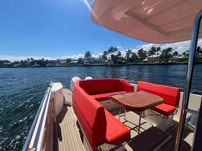 Fla#98 Yacht Photos Pics Nimbus T11 #98 TRADE! 2022 boat with red seating, wooden table, and scenic waterfront view.