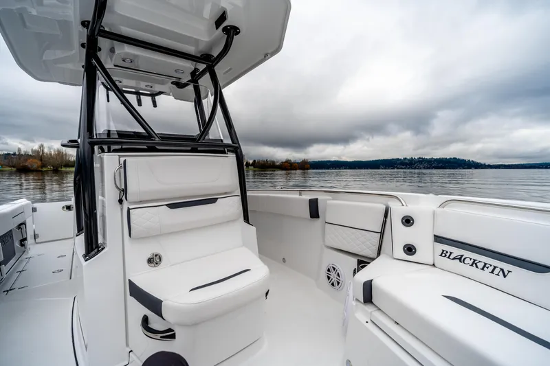 Blackfin 252cc Yacht Photos Pics 2023 Blackfin 252 CC boat interior with seating, on a calm lake under cloudy skies.