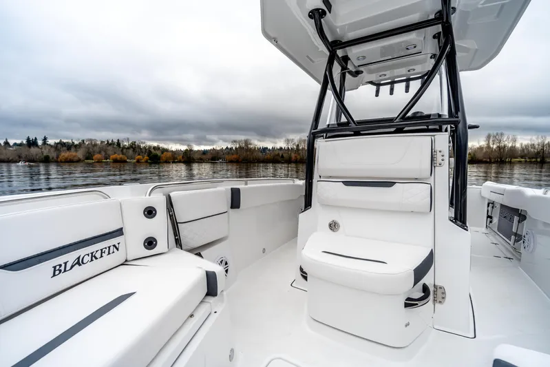 Blackfin 252cc Yacht Photos Pics 2023 Blackfin 252 CC boat interior with seating, on a calm lake under cloudy skies.