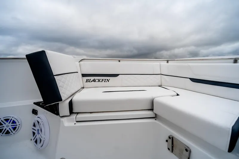 Blackfin 252cc Yacht Photos Pics 2023 Blackfin 252 CC boat with luxurious white seating and overcast sky.