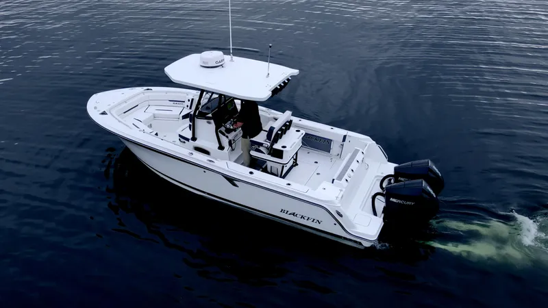 Blackfin 252cc Yacht Photos Pics 2023 Blackfin 252 CC boat cruising on calm water, featuring dual Mercury engines.