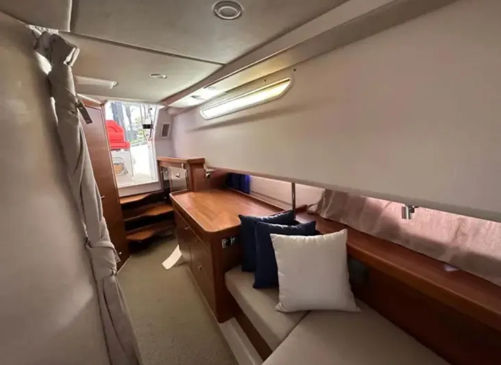 Fla#98 Yacht Photos Pics Cozy interior of 2022 Nimbus T11 #98 TRADE! boat with wooden furnishings and cushions.