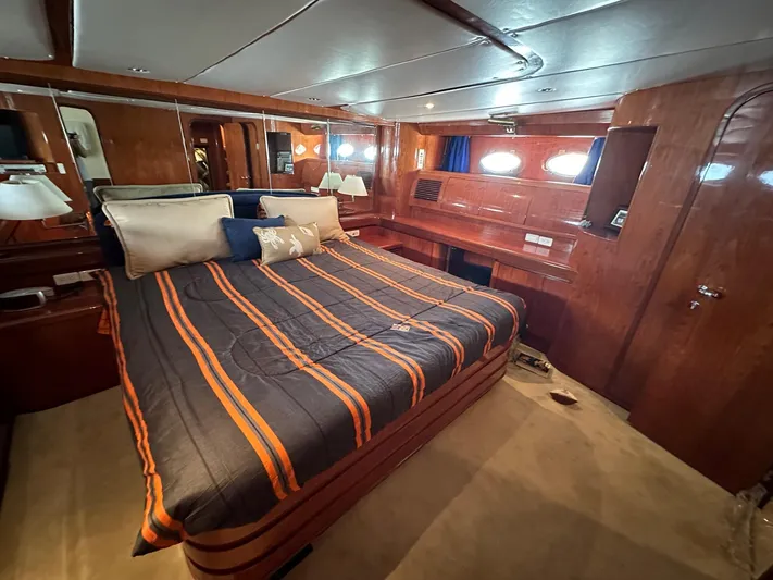 Euphoria Yacht Photos Pics Luxurious cabin interior of 2001 Johnson 70 yacht with striped bedding and wood paneling.