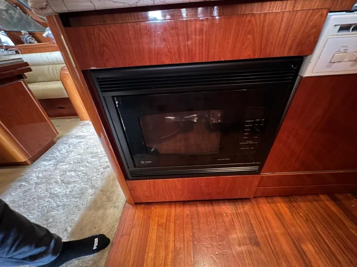 Euphoria Yacht Photos Pics Wood-paneled kitchen with built-in microwave on a 2001 Johnson 70 yacht.