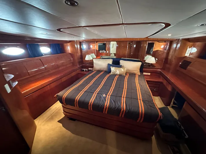 Euphoria Yacht Photos Pics Luxurious cabin interior of 2001 Johnson 70 yacht with wood paneling and cozy bedding.