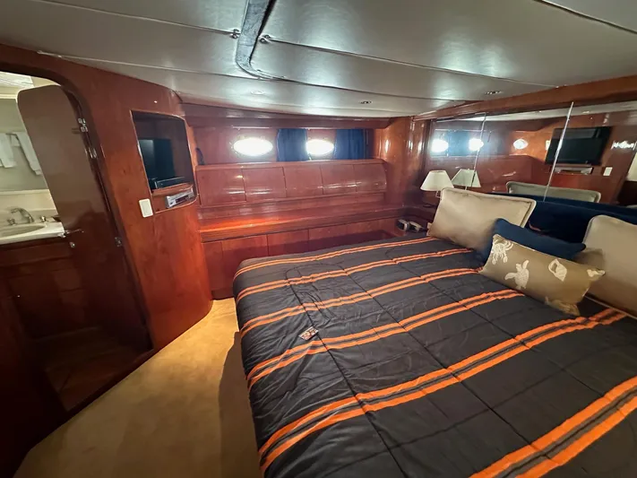 Euphoria Yacht Photos Pics Luxurious cabin interior of 2001 Johnson 70 yacht with cozy bed and wooden furnishings.