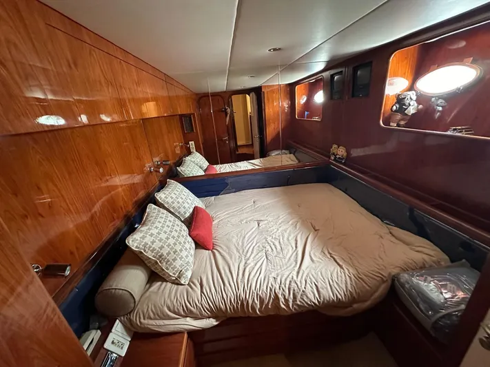 Euphoria Yacht Photos Pics Luxurious cabin interior of a 2001 Johnson 70 yacht with wood paneling and cozy bedding.