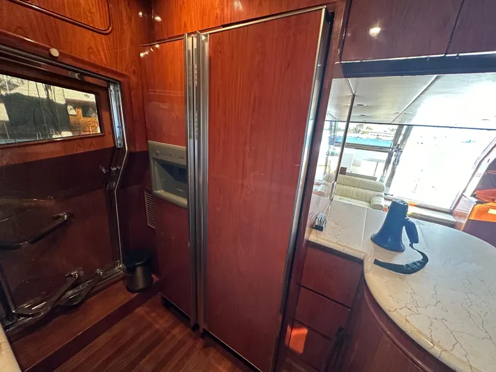 Euphoria Yacht Photos Pics Luxurious yacht interior with wood paneling, modern kitchen, and large refrigerator. Johnson 70, 2001 model.