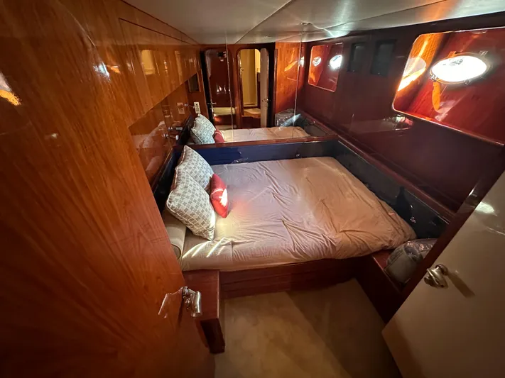 Euphoria Yacht Photos Pics Luxurious cabin interior of 2001 Johnson 70 yacht with wooden finish and cozy bedding.