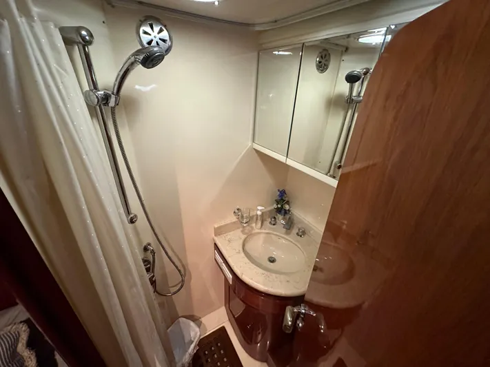 Euphoria Yacht Photos Pics Compact bathroom in a 2001 Johnson 70 yacht with shower and sink.
