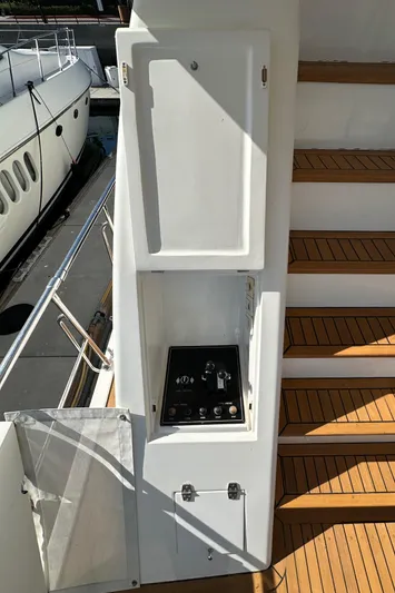 Euphoria Yacht Photos Pics Control panel on 2001 Johnson 70 yacht, near wooden steps and docked boat.
