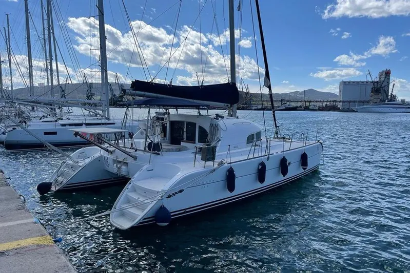 Lagoon 380 Yacht Photos Pics 2002 Lagoon 380 catamaran docked in a marina under a blue sky.