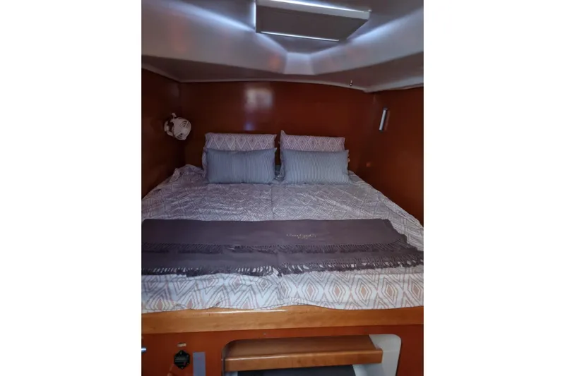 Lagoon 380 Yacht Photos Pics Cozy cabin bedroom in 2002 Lagoon 380 catamaran with patterned bedding and wooden accents.