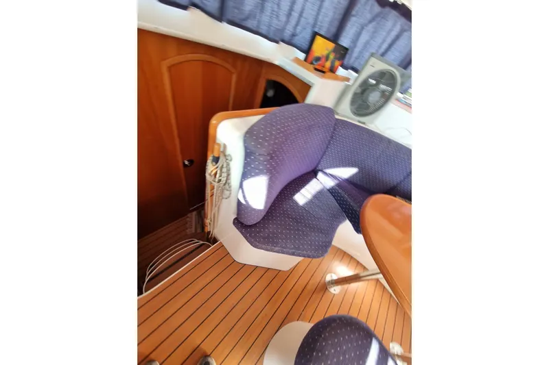 Lagoon 380 Yacht Photos Pics Interior of 2002 Lagoon 380 catamaran with wooden flooring and blue seating.