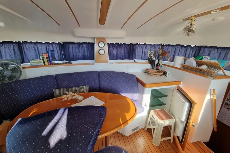 Lagoon 380 Yacht Photos Pics Interior of 2002 Lagoon 380 catamaran with cozy seating, table, and nautical decor.