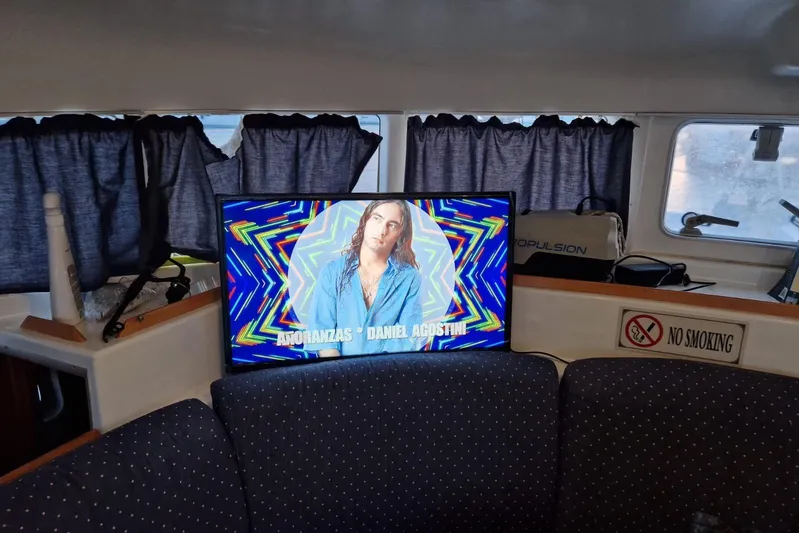 Lagoon 380 Yacht Photos Pics Interior of 2002 Lagoon 380 catamaran with TV displaying colorful graphics and "No Smoking" sign.