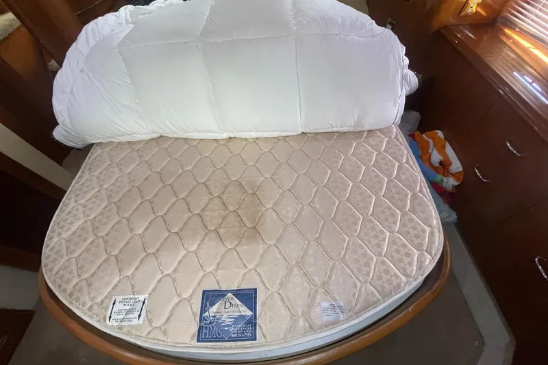 Rudee's Ruckus Yacht Photos Pics Bed in 2006 Carver 46 Motor Yacht cabin with quilted mattress and white bedding.