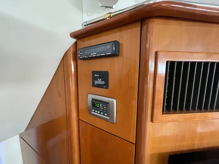 Rudee's Ruckus Yacht Photos Pics 2006 Carver 466 Motor Yacht interior with control panel and wooden cabinetry.