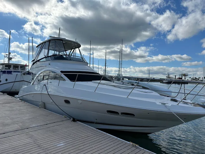  Yacht Photos Pics 2008 Sea Ray 47 Sedan Bridge yacht docked at marina under cloudy sky.