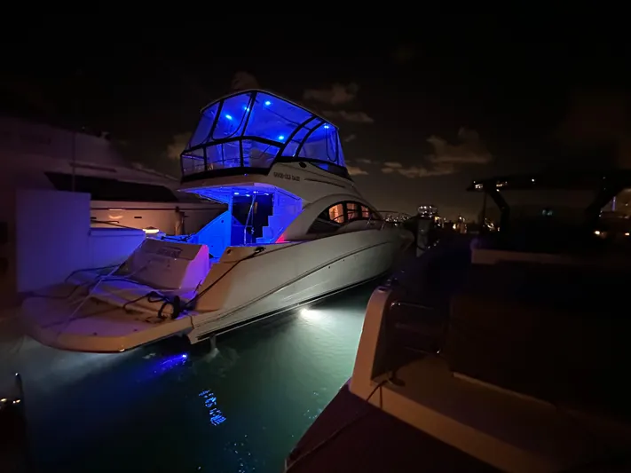  Yacht Photos Pics 2008 Sea Ray 47 Sedan Bridge yacht illuminated with blue lights at night.