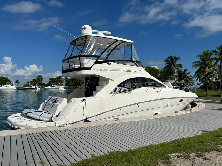  Yacht Photos Pics 2008 Sea Ray 47 Sedan Bridge yacht docked by palm trees under blue sky.