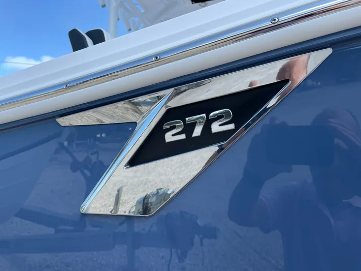 Med Blue Yacht Photos Pics 2025 Blackfin 272CC boat emblem on a sleek blue surface.