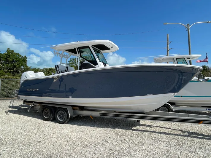 Med Blue Yacht Photos Pics 2025 Blackfin 272CC boat on trailer under clear blue sky.