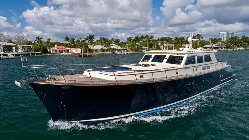 Essence Yacht Photos Pics 2006 Vicem 85 Classic yacht cruising on a sunny day with coastal homes in the background.