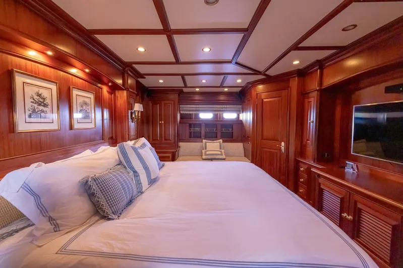 Essence Yacht Photos Pics Luxurious wood-paneled bedroom in 2006 Vicem 85 Classic yacht with elegant bedding and decor.