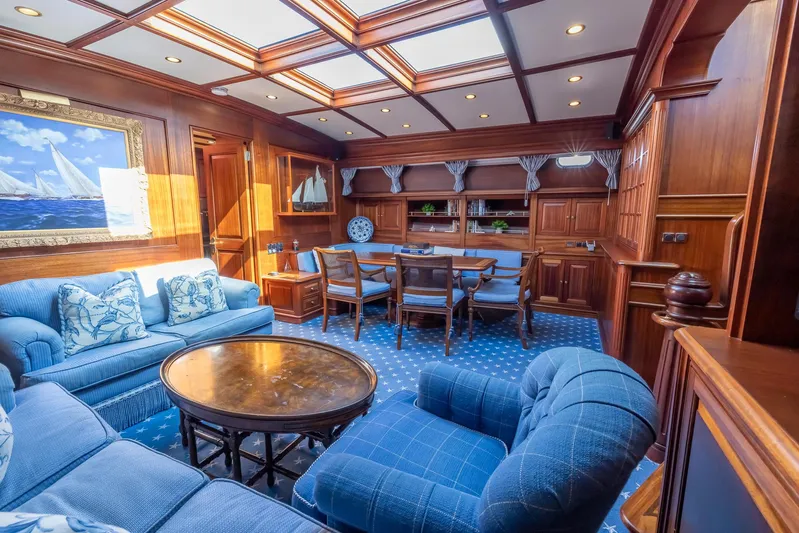 Essence Yacht Photos Pics Luxurious interior of 2006 Vicem 85 Classic yacht with elegant wood paneling and plush blue seating.